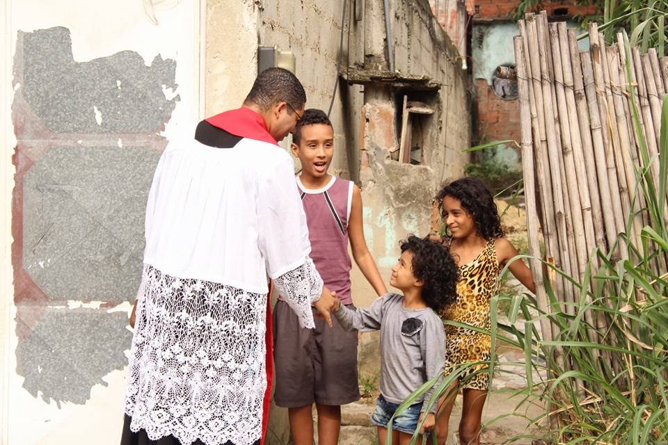 Pater Douglas hälsar på barn från periferin.
