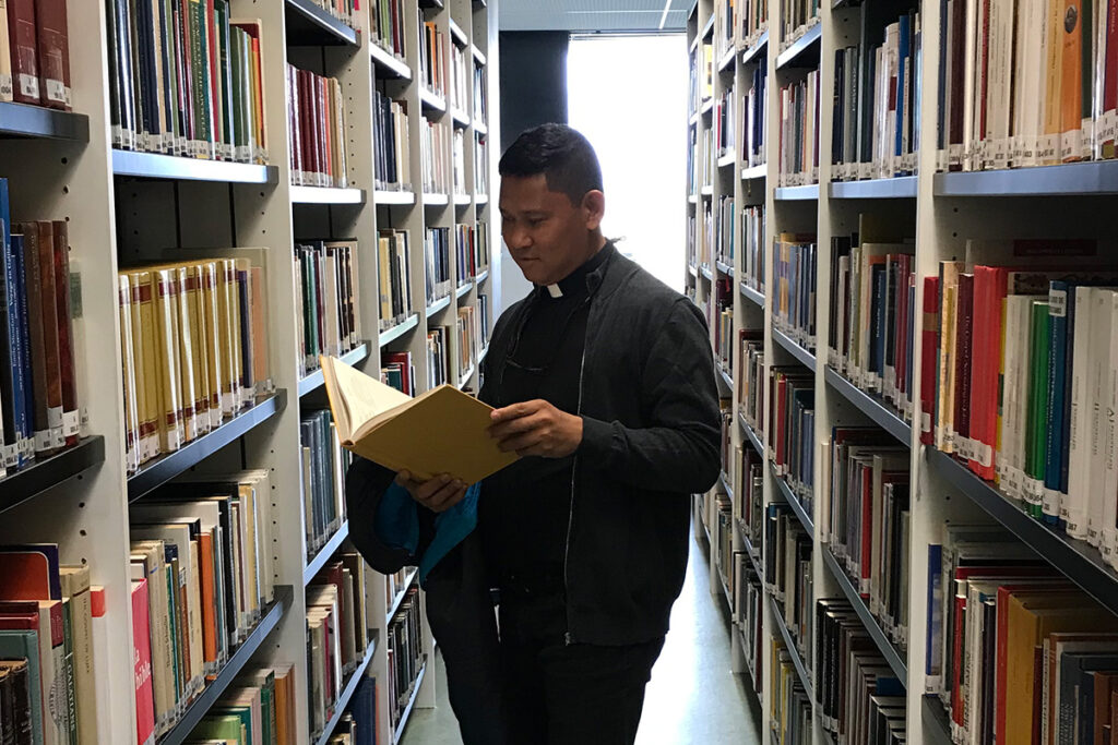 sacerdote anthony laureta leyendo un libro