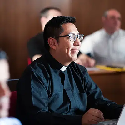 Diocesan priest attending during a class