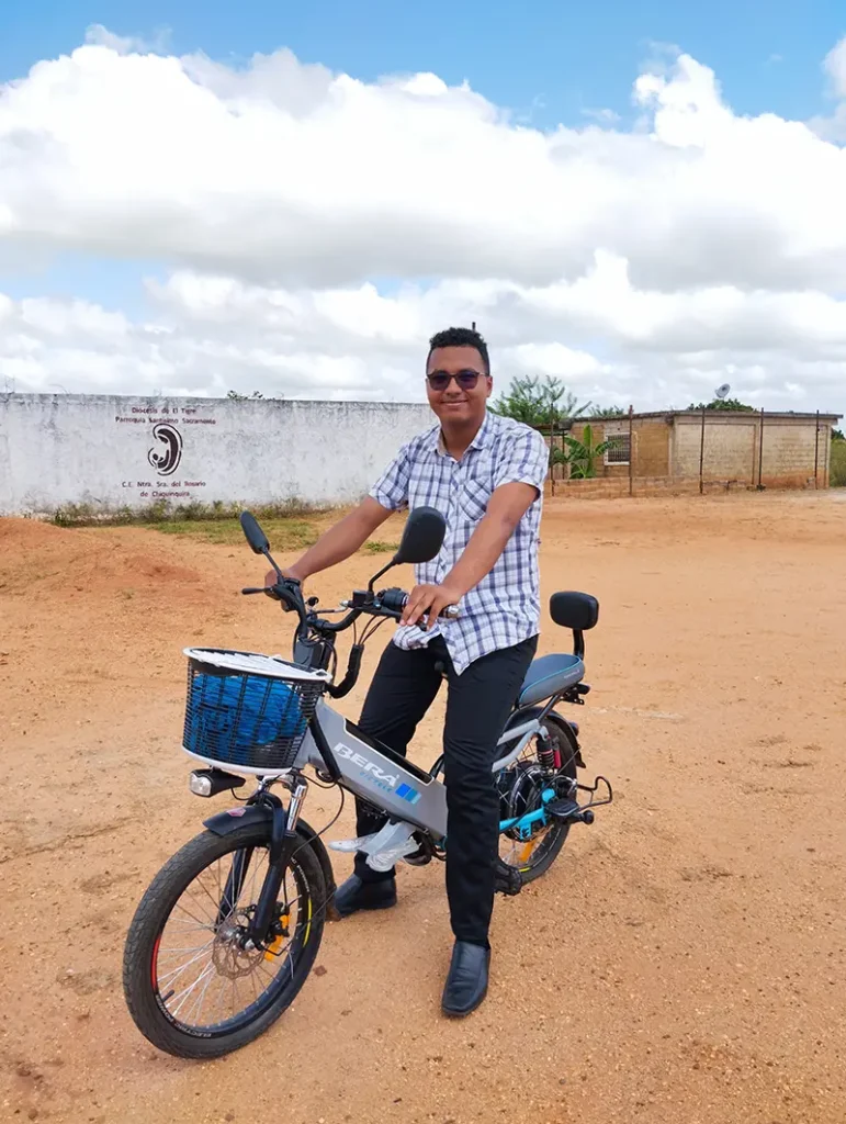 Leonardo posa subido a una motocicleta en su pueblo nata, en Venezuela, mientra piensa en Dios.