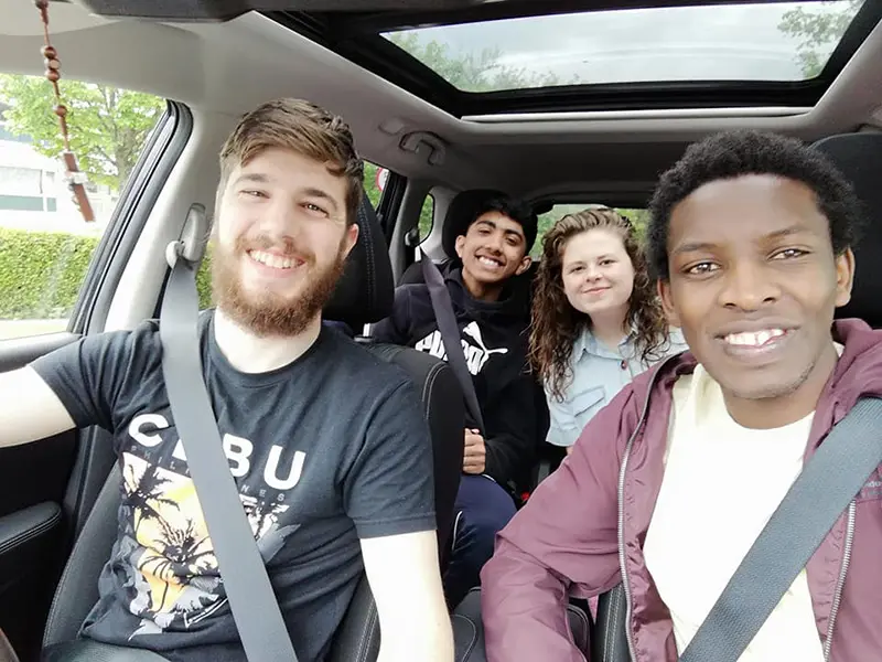 Samuel se jako teenager usmívá se třemi kamarády v autě během NET v Irsku.